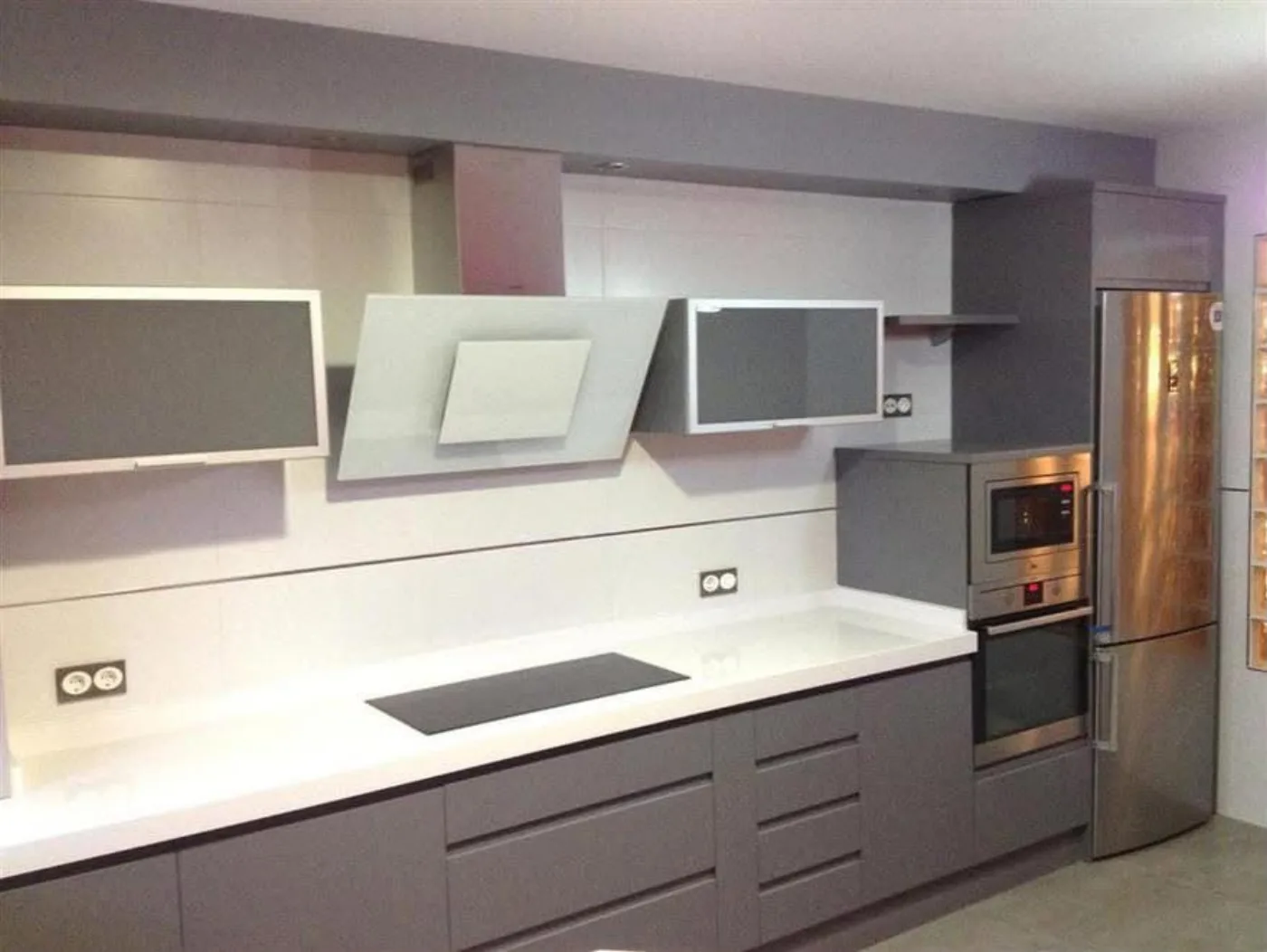 Cocina de frentes grises con isla y campana integrada